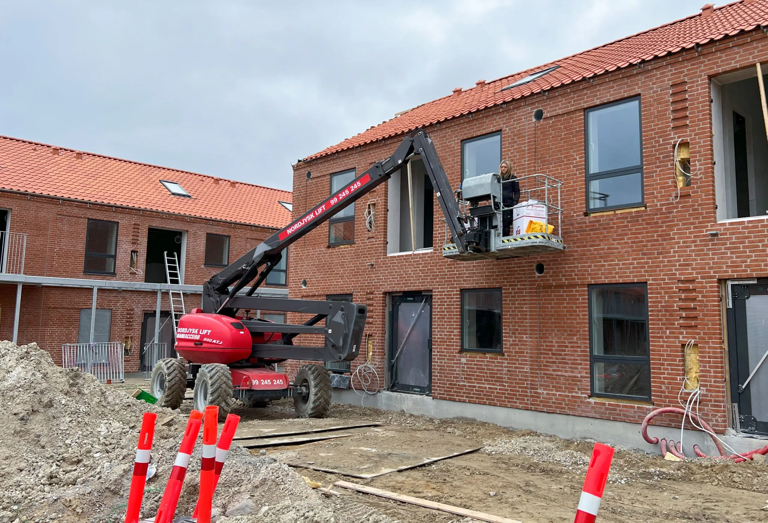 Gummifugen udfører montering af diffusionsåbent fugebånd omkring vinduer i nybyggeri fra lift